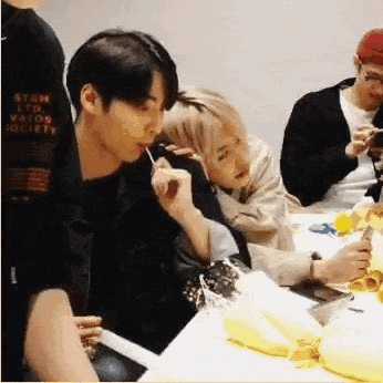 a man and a woman are sitting at a table eating a banana .
