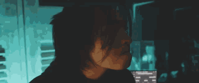 a close up of a person 's face with a computer in the background