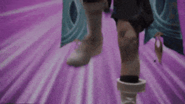 a person 's feet are walking on a purple and white striped floor .