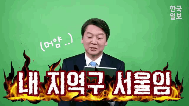 a man in a suit and tie is holding a tablet in front of a green screen with flames coming out of it in korean