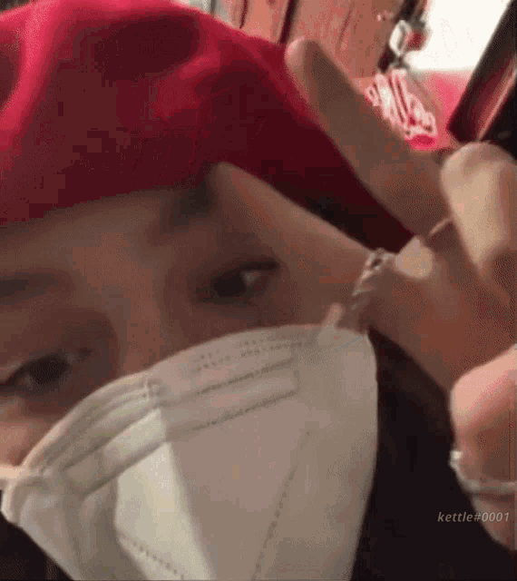 a person wearing a red beret and a white face mask