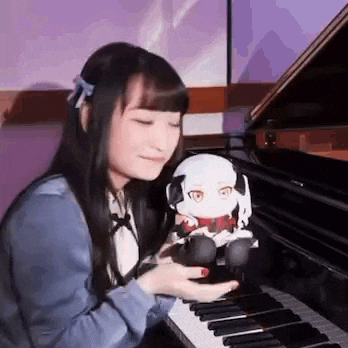 a woman is playing the piano and holding a stuffed animal .