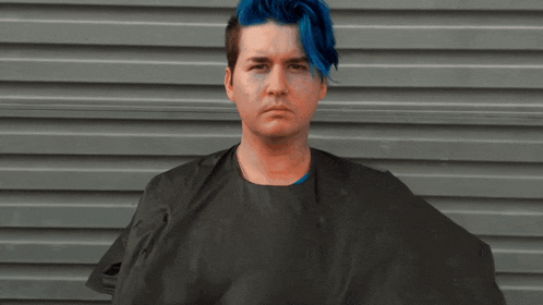 a man with blue hair and a black cape
