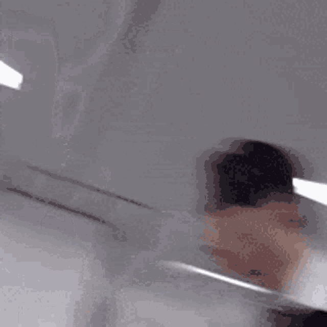 a blurry picture of a man in a suit standing in front of a white light .