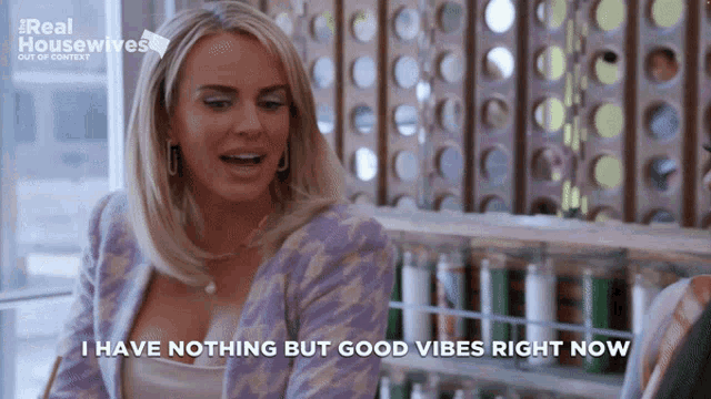 a woman says i have nothing but good vibes right now while sitting at a table