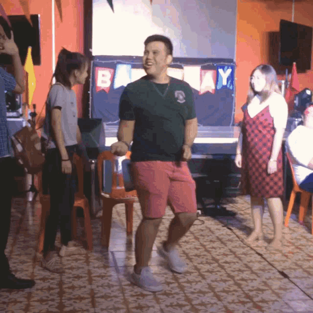 a man is dancing in front of a banner that says ' bay '