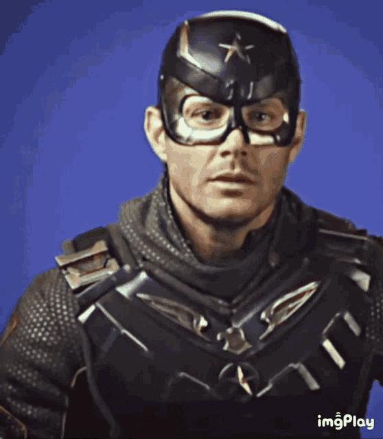 a close up of a man wearing a superhero costume with a star on his helmet