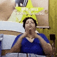 a woman in a blue shirt is sitting on a bed .