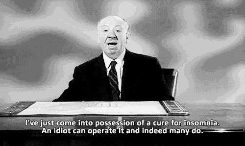 a man in a suit and tie is sitting at a desk with a piece of paper on it .