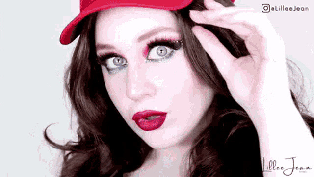 a close up of a woman wearing a red hat with a littlee jean logo in the corner