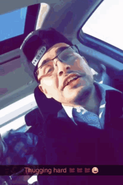 a man wearing glasses and a hat is sleeping in the back seat of a car with a caption that says thugger hard