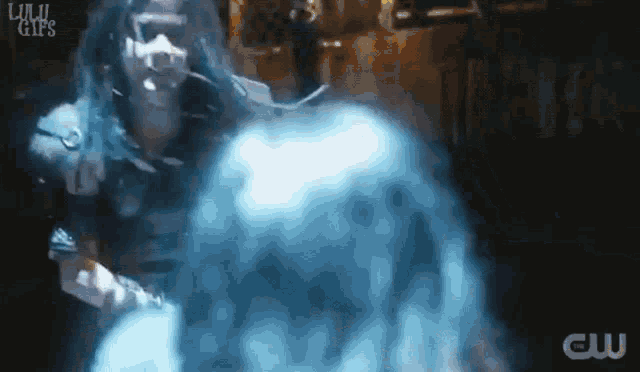 a man in a mask is surrounded by smoke and a cw logo