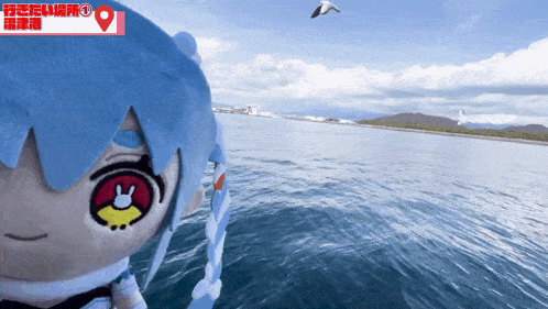 a stuffed animal with chinese writing on it looks out over a large body of water