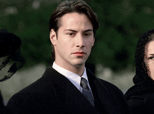 a man in a suit and tie is standing next to a woman