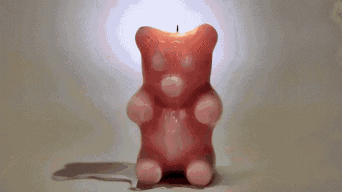 a pink gummy bear shaped candle with a candle sticking out of it