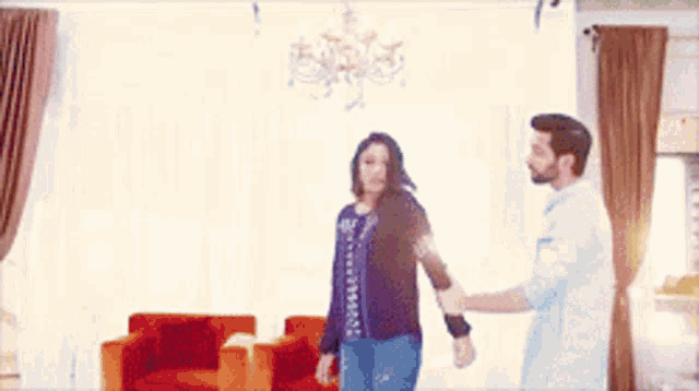 a man and a woman are dancing in a living room .