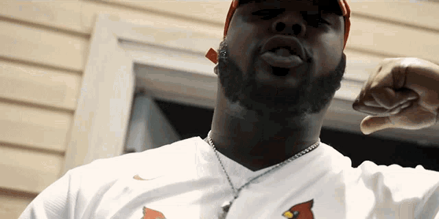 a man wearing a cardinals shirt is pointing