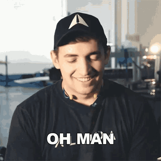 a man wearing a black shirt that says oh man is smiling