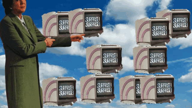 a woman in a green suit holds up a stack of surprise surprise boxes