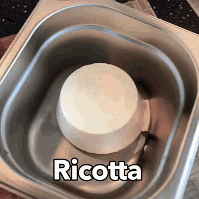 a container of ricotta sits in a metal container