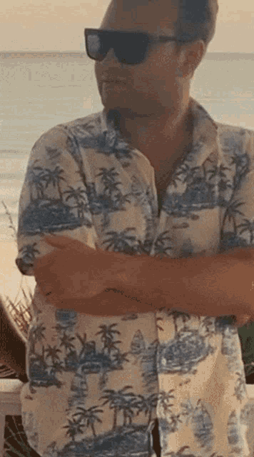 a man wearing sunglasses and a hawaiian shirt
