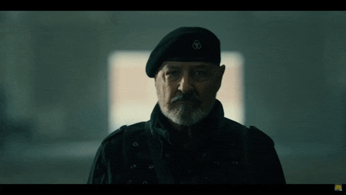 a man with a beard wearing a black beret