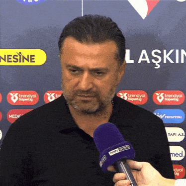 a man with a beard is being interviewed with a microphone that says bein sports on it