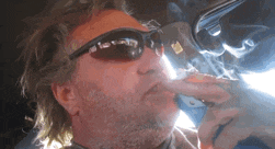 a man wearing sunglasses is smoking a cigar