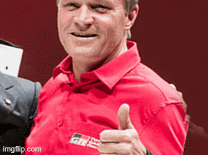 a man wearing a red shirt with a toyota logo on it giving a thumbs up