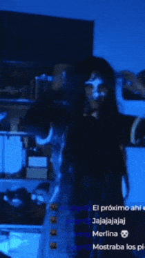 a woman with a mask on her face is standing in a dark room with a blue background