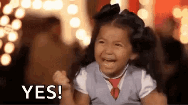 a little girl is crying and holding her fist up in the air .