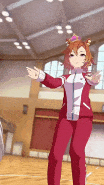 a girl in a red jacket and pants is standing in a gym with her arms outstretched .