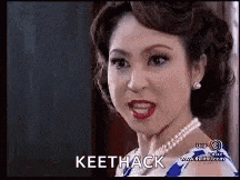 a woman wearing a pearl necklace is making a funny face and looking at the camera .