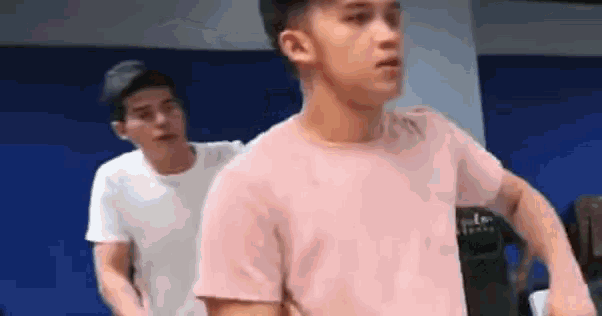 a couple of young men are standing next to each other in a room .