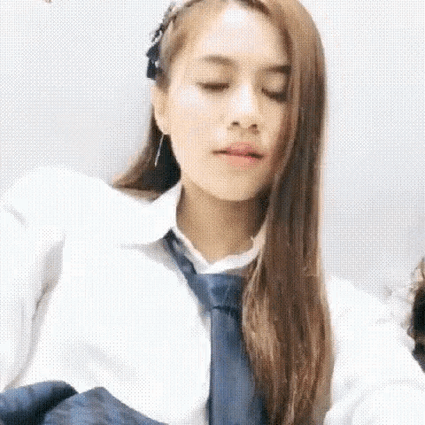 a woman wearing a white shirt and a blue tie is looking down .