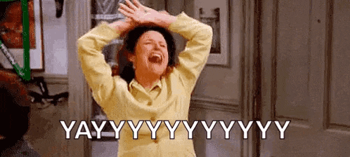 a woman in a yellow shirt is laughing with her hands on her head and the words yay written above her .