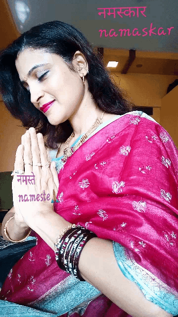 a woman in a pink saree is praying with namaste written on her hands