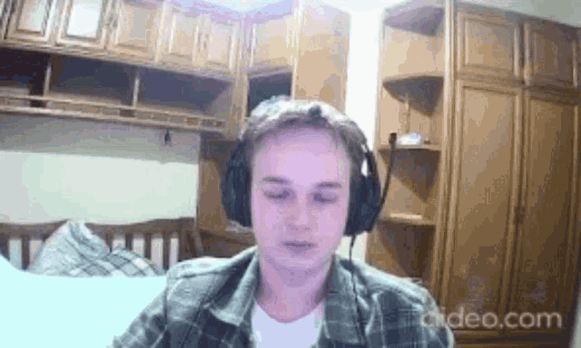 a man wearing headphones is sitting on a couch in a room .