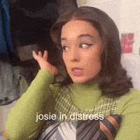 a woman wearing a green turtleneck and a tie has the words josie in distress written on her face