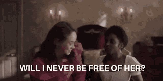 two women are sitting on a bed and one of them is asking the other if she 'll never be free of her .
