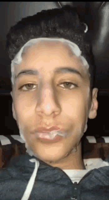 a close up of a young man 's face with a facial mask on it .