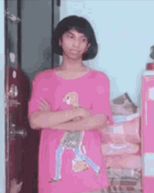 the girl is wearing a pink shirt with a picture of a man on it .