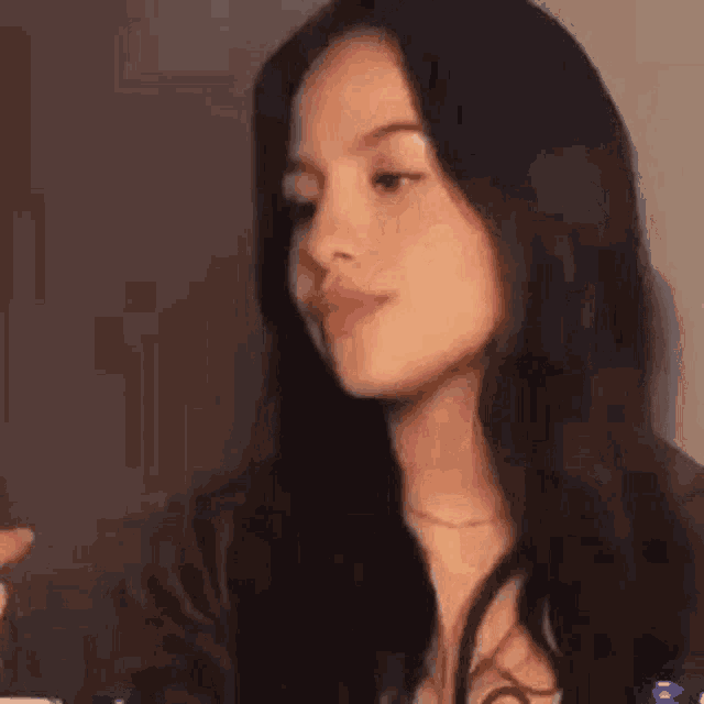 a close up of a woman 's face with long black hair looking at the camera .