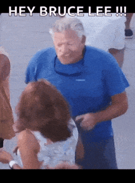 a man in a blue shirt is talking to a woman in a white dress