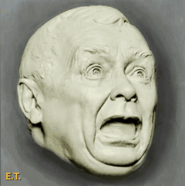 a statue of a man 's face with e.t. written on the bottom right