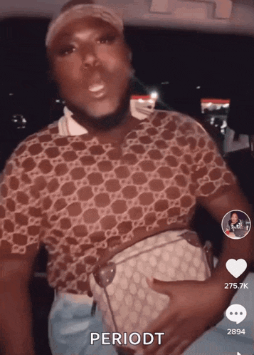 a man wearing a gucci shirt is holding a purse in his hand