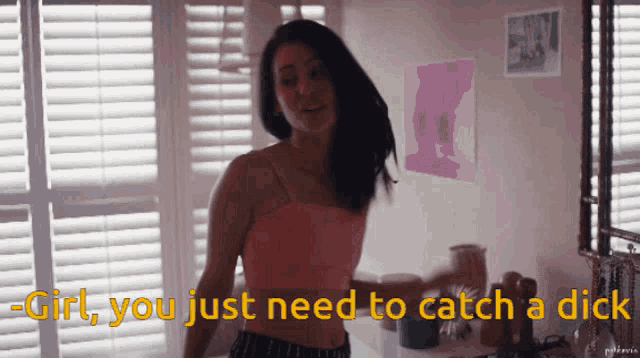 a woman in a pink top is standing in front of a window with the words " girl you just need to catch a dick " above her