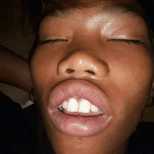 a close up of a person 's face with their eyes closed .