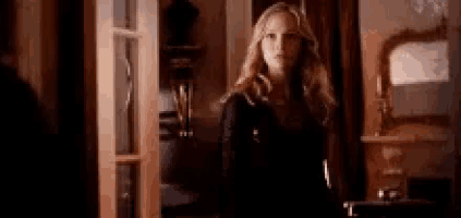 a woman is standing in front of a door in a room and looking at the camera .