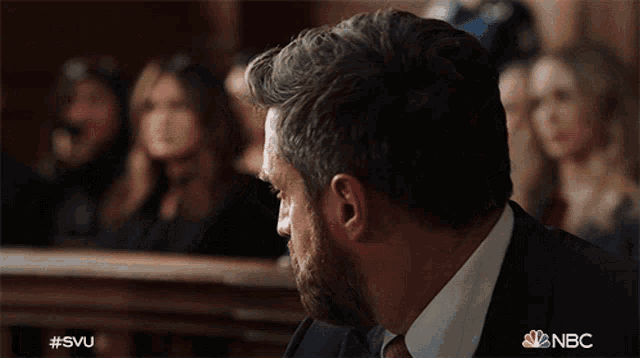 a man in a suit and tie is sitting in a courtroom with nbc written on the bottom